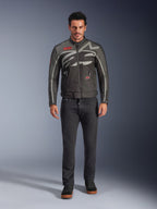Giacca Alpinestars Axton, giacca da moto, nero antracite rosso tangerine, indossata da un modello con pantaloni scuri, con logo Alpinestars grigio avvolgente, patch del marchio rosse e guscio in tessuto resistente all'acqua per la guida urbana