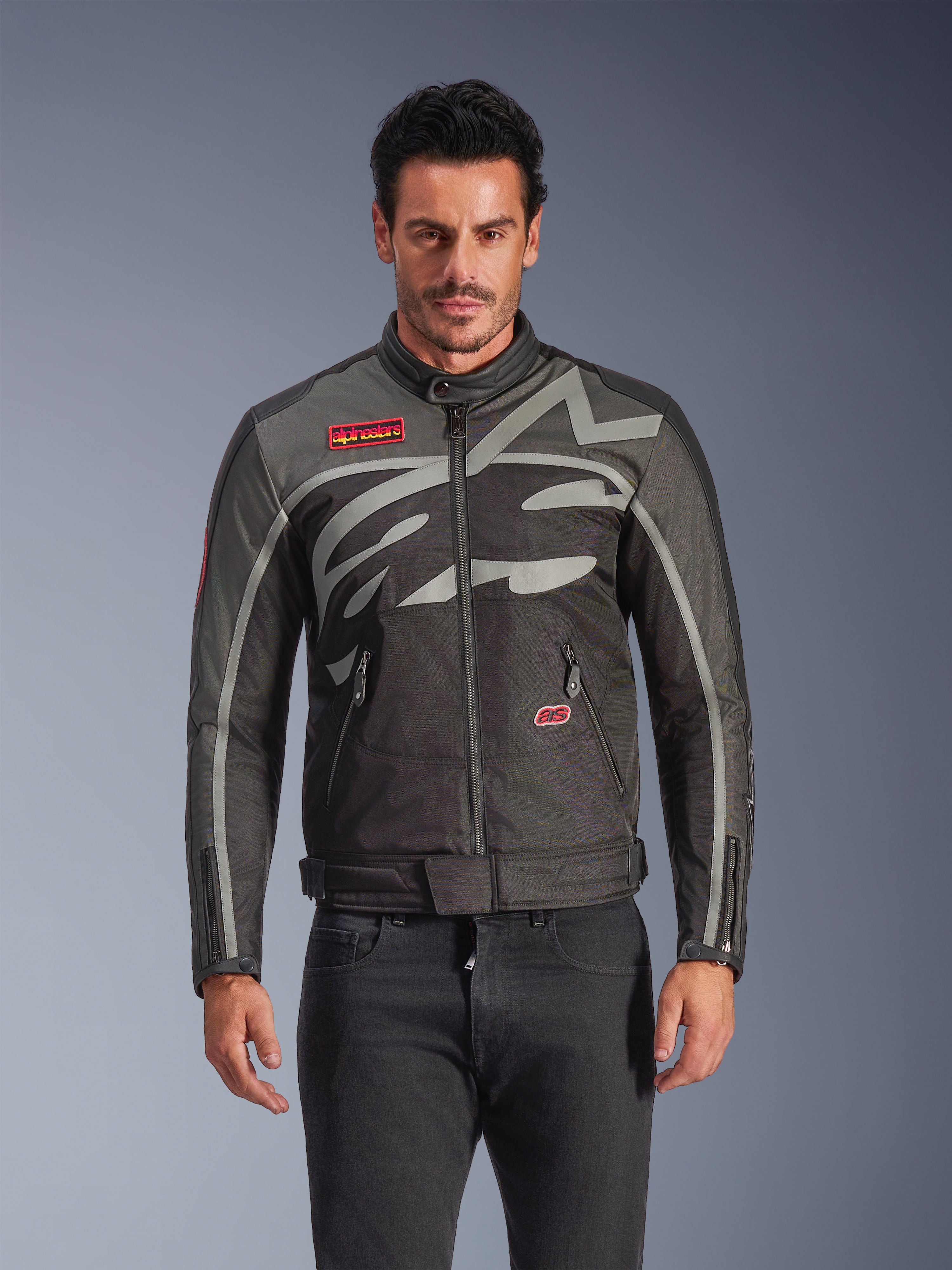 Alpinestars Axton Jacket, giacca da moto urbana da uomo, nero e antracite con accenti rossi, con una grande grafica grigio chiaro avvolgente, patch con logo rosso sul petto e sulla tasca, zip frontale e polsini con cerniera, design racing d'ispirazione vintage per uso stradale