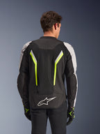 Alpinestars AST V3 Air Jacket, Black Silver Yellow Fluo, vista posteriore su modello, giacca da moto in tessuto con pannelli di ventilazione in doppia rete tecnica, strisce verticali giallo fluo, maniche argento e logo Alpinestars bianco sulla parte bassa della schiena