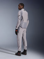 Giacca Alpinestars Aeroshell Airflow in Mid Gray Anthracite, indossata con pantaloni coordinati e guanti da corsa neri, vista posteriore che mostra i pannelli traforati al laser e la vestibilità sportiva atletica, abbigliamento professionale da moto