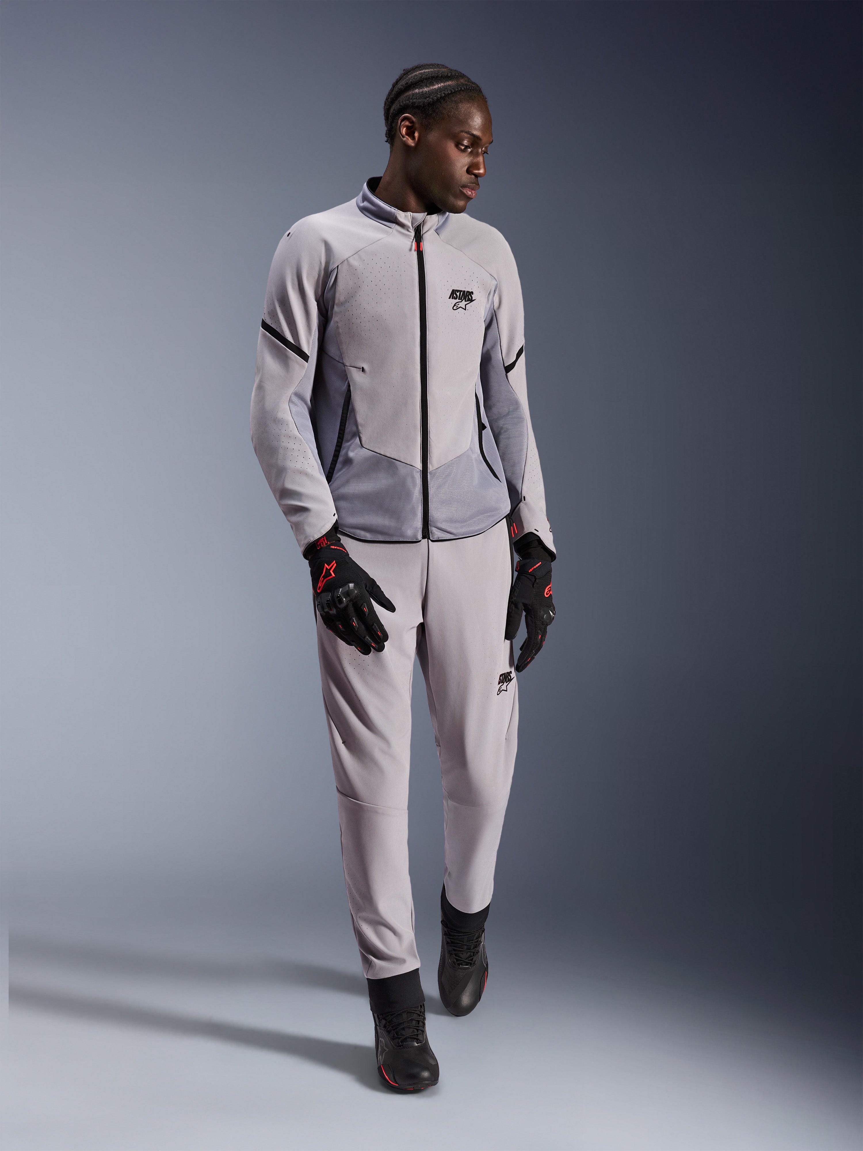 Giacca Alpinestars Aeroshell Airflow, Grigio Medio Antracite, giacca da moto in tessuto con perforazioni laser e pannelli in rete, indossata con pantaloni coordinati e accessori da moto neri, design leggero e sportivo per prestazioni con climi caldi