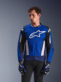 Alpinestars T-GP Air Jacket, giacca da moto sportiva in tessuto, blu brillante e navy con accenti bianchi, con grande logo a stella sul petto e pannelli di ventilazione in mesh, indossata da un modello con guanti coordinati e pantaloni neri