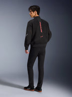 Modello con giacca Alpinestars Flight Air in Black Bright Red, vista posteriore che mostra il marchio rosso verticale sulla schiena e la costruzione in mesh 3D, abbinata a pantaloni neri e sneakers, stile motociclistico urbano