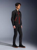 Giacca Alpinestars Flight Air, Nero Rosso Brillante, giacca da moto urbana in stile bomber indossata da un modello, dotata di pannelli in mesh 3D e cerniere rosse a contrasto, abbinata a pantaloni neri e scarpe da guida casual, abbigliamento protettivo moderno di ispirazione streetwear