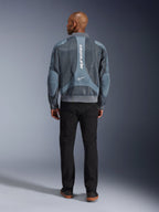 Giacca Alpinestars Flight Air in Storm Gray, vista posteriore di un modello che indossa una giacca da moto in stile urban con pannelli in mesh 3D e logo Alpinestars verticale, abbinata a pantaloni neri per un look da commuter moderno