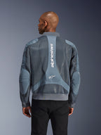 Giacca Alpinestars Flight Air in Storm Gray, vista posteriore su un modello, giacca da moto urbana con ampi pannelli in mesh 3D, marchio Alpinestars verticale sulla schiena e colletto e orlo a costine in stile bomber.