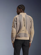 Giacca Alpinestars Flight Air, giacca da moto urbana, color sabbia, vista posteriore con ampi pannelli in mesh 3D e branding Alpinestars verticale sulla schiena, design ispirato ai bomber con orlo a costine, indossata da un modello con pantaloni neri