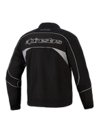 Giacca Alpinestars Unite, vista posteriore, nero con pannelli riflettenti grigio scuro, logo Alpinestars con profilo bianco sulla schiena, giacca da moto urbana in softshell dal design minimalista