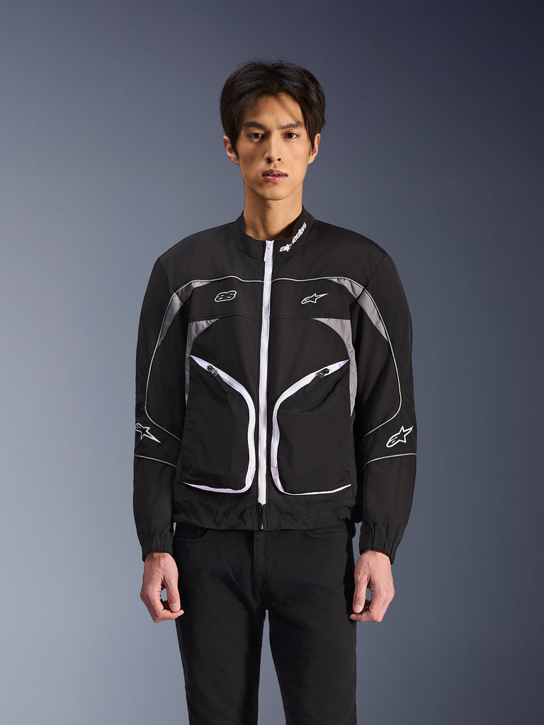 Alpinestars Unite Jacket, giacca urbana da moto nera con dettagli bianchi, zip frontale, linee curve sul petto, loghi sul petto e sulle maniche, design sportivo moderno