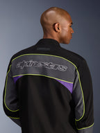 Giacca Alpinestars Unite, giacca da moto urban, Black Asphalt Violet, vista posteriore che mostra un ampio pannello grigio sulle spalle con logo Alpinestars, bordature giallo neon e accenti viola su una costruzione in softshell a 3 strati