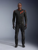Giacca Alpinestars Viper Air V4 in Nero Rosso Fluo, indossata da un modello con pantaloni e guanti neri coordinati, dotata di pannelli in mesh per la circolazione dell'aria e un evidente logo Alpinestars rosso sul petto, abbigliamento sportivo da moto da strada.