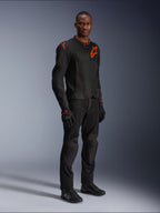 Modello che indossa la giacca Alpinestars Viper Air V4 in nero e rosso fluo, con pannelli in rete e loghi a stella rossi sul petto e sulla spalla, abbinata a pantaloni da moto, guanti e scarpe da guida neri coordinati, completo professionale per la guida su strada