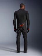 Alpinestars Viper Air V4 Jacket, nero e rosso fluo, vista posteriore su modello, indossata con pantaloni da moto e guanti neri coordinati, caratterizzata da un vivace logo rosso fluorescente sulla parte bassa della schiena, costruzione in rete per il flusso d'aria, vestibilità atletica per la guida su strada in moto.