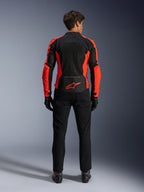 Giacca Alpinestars Viper Air V4, rosso fluo e nero, vista posteriore con ampi pannelli in mesh tecnico e accenti laterali in rosso fluorescente, logo Alpinestars rosso sulla parte bassa della schiena, indossata con pantaloni da guida e guanti neri.