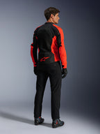 Giacca Alpinestars Viper Air V4, Rosso Fluo Nero, vista posteriore su modello, con pannelli in rete tecnica e logo a stella rosso sulla parte inferiore della schiena, abbinata a pantaloni e guanti da moto neri per un look completo da strada.