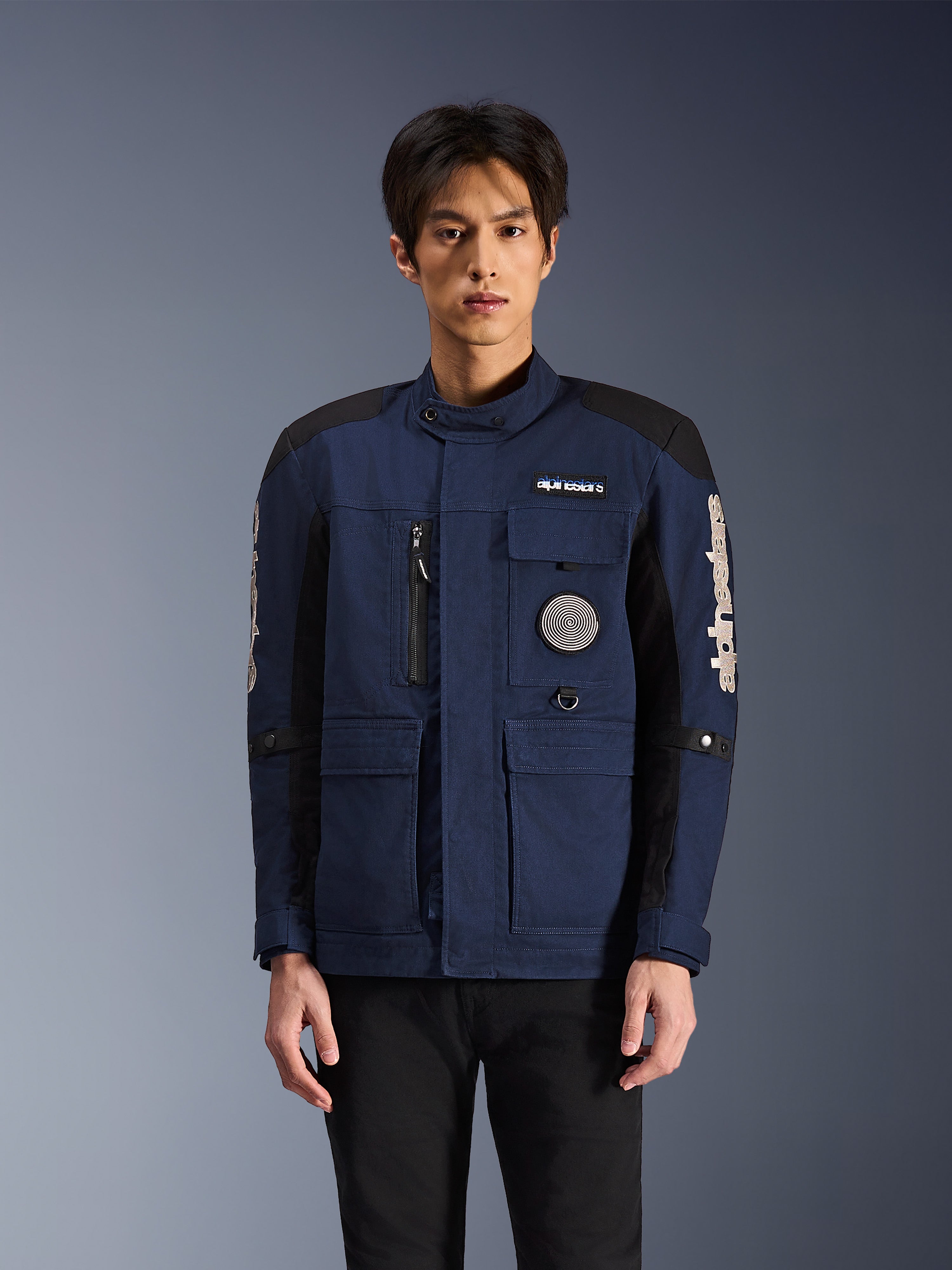 Alpinestars Dice Jacket, giacca da moto urbana, blu scuro e nero, con design field jacket multi-tasca, patch a spirale sul petto e branding Alpinestars bianco sulle maniche, abbigliamento da moto moderno ispirato al workwear