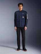 Alpinestars Dice Jacket, giacca da moto urban, blu scuro e nero, indossata da un modello con pantaloni neri e scarpe nere, design moderno da giacca da campo con tasche multiple, cerniera verticale sul petto e marchio Alpinestars bianco sulle maniche.