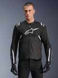 Alpinestars Giacca T-SPS Air V2, giacca da moto in tessuto, nera con dettagli bianchi, grande logo bianco sul petto, design in mesh traforato per la ventilazione, indossata con pantaloni e guanti neri