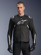Alpinestars Giacca T-SPS Air V2, giacca da moto in tessuto, nera con dettagli bianchi, grande logo bianco sul petto, design in mesh traforato per la ventilazione, indossata con pantaloni e guanti neri