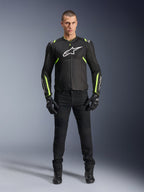 Giacca Alpinestars T-Sps Air V2, nero e giallo fluo, giacca da moto in tessuto con pannelli in rete, indossata da un modello uomo con pantaloni e guanti neri, con logo Alpinestars bianco sul petto, abbigliamento da moto urban sport