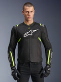 Alpinestars Giacca T-Sps Air V2 in Nero Giallo Fluo, modello maschile che indossa la giacca in tessuto ventilato con pannelli in rete e logo bianco sul petto, abbinata a guanti da moto neri, abbigliamento da moto urbano