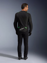 Giacca Alpinestars T-SPS Air V2, giacca da moto, nero e verde fluo, vista posteriore con logo bianco sulla parte bassa della schiena, indossata con pantaloni e stivali neri coordinati, design in rete ventilata per guida sportiva