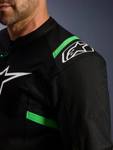Giacca Alpinestars T-SPS Air V2, nero e verde fluo, primo piano della zona della spalla e del torace, logo Alpinestars a stella bianco, tessuto in rete tecnica per il flusso d'aria, giacca da moto sportiva