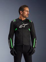 Giacca Alpinestars T-SPS Air V2, giacca da moto, nero e verde fluo, indossata da un modello con guanti e pantaloni neri, logo Alpinestars bianco sul petto e accenti verde neon su spalle e maniche, pannelli in rete tecnica per la ventilazione, design dal taglio sportivo per guida urbana