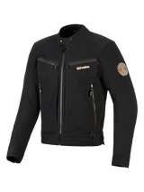 Giacca Alpinestars Bruiser, giacca da moto urbana nera, dotata di tasche con zip sul petto e per le mani, branding color oro e patch Oscar a spirale sulla spalla, design tessile ispirato al workwear.