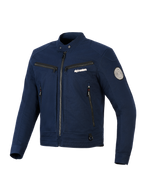 Giacca Alpinestars Bruiser, giacca da moto urban in tessuto, blu scuro, design ispirato al workwear con zip frontale e tasche sul petto, colletto con bottone a pressione e patch Oscar a spirale sulla manica, estetica streetwear contemporanea