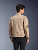 Giacca Alpinestars Bruiser, giacca da moto urbana marrone, vista posteriore che mostra le spalle plissettate articolate e i regolatori in vita, indossata con pantaloni neri, abbigliamento da moto contemporaneo ispirato allo stile workwear