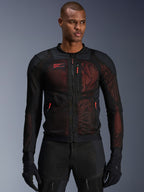 Alpinestars Troop-Air Pro Jacket, giacca da moto tecnica corazzata, nero e rosso fluo, dotata di tiretti delle cerniere rossi e logo Alpinestars, pannelli in mesh traspirante con sottostrato rosso, indossata con pantaloni e guanti da moto neri coordinati