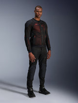 Giacca Alpinestars Troop-Air Pro in Nero Rosso Fluo, giacca da moto tecnica in mesh corazzata indossata da un modello uomo con pantaloni neri corazzati coordinati e stivali alti, ritratto in studio a figura intera.