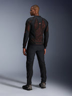 Giacca Alpinestars Troop-Air Pro in Black Red Fluo, vista posteriore su un modello, con un ampio pannello posteriore in mesh tecnica 2D e interno rosso visibile, abbinata a pantaloni tecnici neri e stivali neri e grigi, design moderno di giacca da moto urbana protettiva.