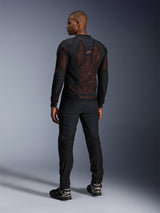 Giacca Alpinestars Troop-Air Pro in Black Red Fluo, vista posteriore su un modello, con un ampio pannello posteriore in mesh tecnica 2D e interno rosso visibile, abbinata a pantaloni tecnici neri e stivali neri e grigi, design moderno di giacca da moto urbana protettiva.