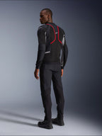 Alpinestars Troop-Air Pro Jacket, giacca da moto, nero, grigio cenere e rosso vivace, vista posteriore su modello, con linee d'accento rosse e pannelli di ventilazione in mesh, indossata con pantaloni e stivali neri, stile motociclistico urbano