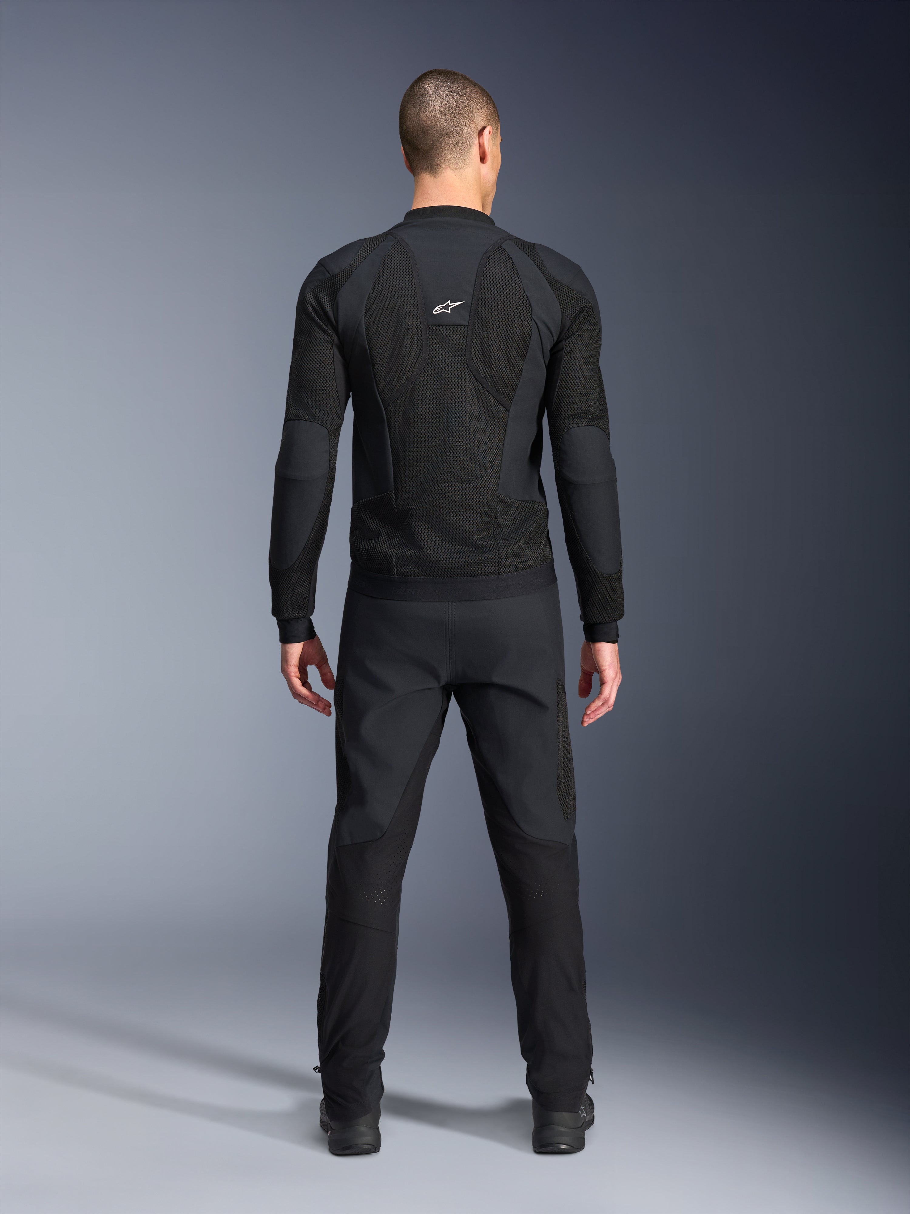 Giacca Alpinestars Troop-Air Pro, vista posteriore, nero, giacca tecnica da moto ventilata con ampi pannelli di ventilazione in mesh e logo Alpinestars bianco, abbinata a pantaloni neri, abbigliamento da moto urban contemporary