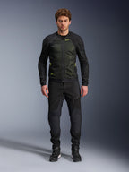 Modello che indossa la giacca Alpinestars Troop-Air in Nero Giallo Fluo, con pannelli in mesh tecnico e accenti giallo brillante, abbinata a pantaloni da moto e scarpe neri, abbigliamento da moto contemporaneo per climi caldi