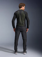 Giacca Alpinestars Troop-Air, Nero Giallo Fluo, vista posteriore su un modello, con ampio pannello posteriore in mesh tecnico 2D per la ventilazione, giacca tecnica da moto indossata con pantaloni da moto e stivali neri, stile motociclistico urbano