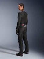 Giacca Alpinestars Stella T-Sps Air v2 da donna, nero e Diva Pink, giacca da moto in tessuto vista da una prospettiva posteriore-laterale, con ampi pannelli in mesh per il flusso d'aria e logo a stella bianco sulla schiena, indossata con pantaloni da moto, guanti e stivali coordinati neri.