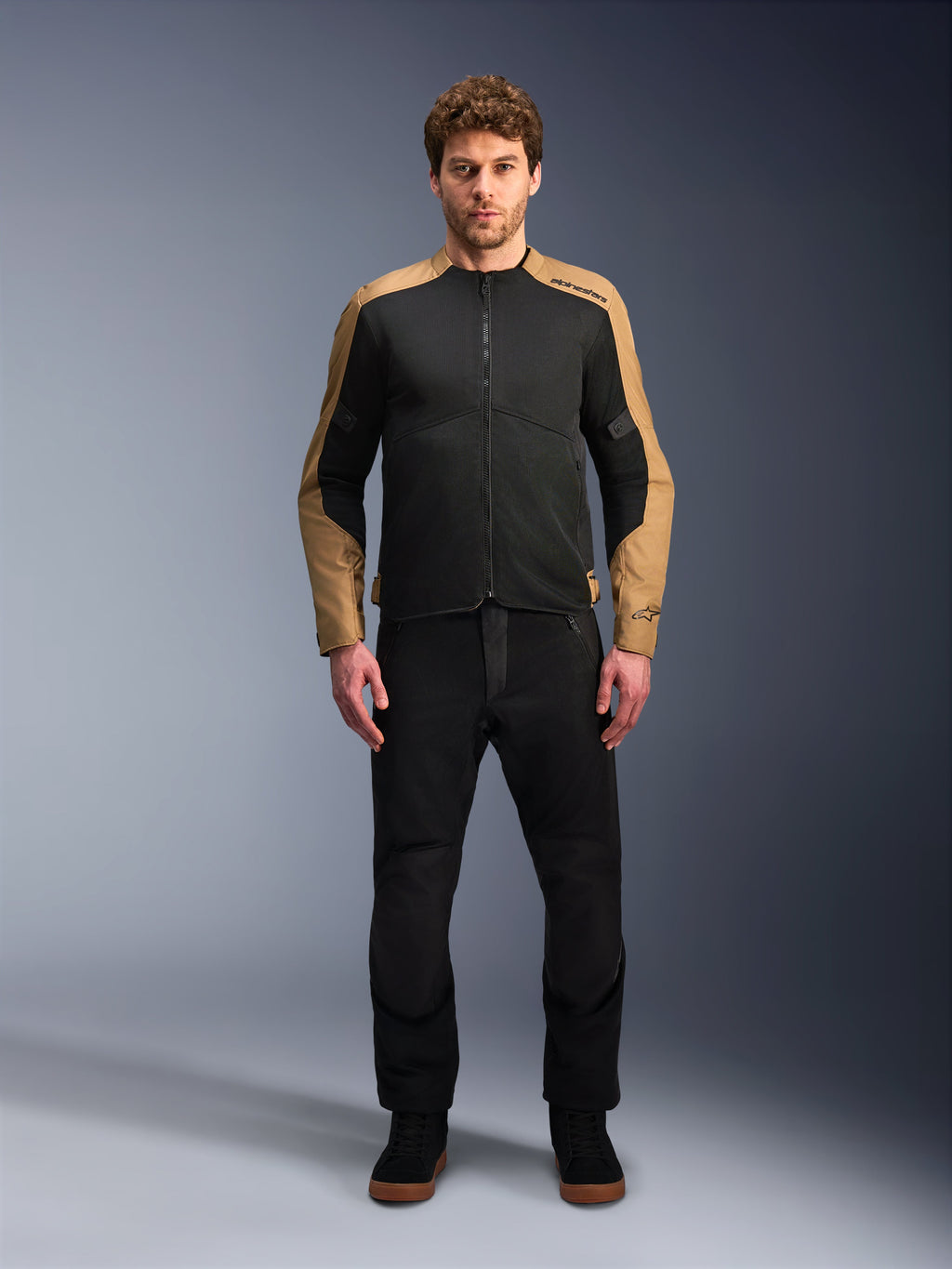 Alpinestars Giacca C-1 Air, giacca da moto urban da uomo, nera e sabbia, in tessuto tecnico con pannelli in rete traspirante, indossata da un modello