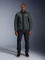 Giacca Alpinestars Ignite Air in Urban Gray Black Blue, giacca da moto stile Harrington con colletto a camicia e costruzione in rete, indossata da un uomo con jeans in denim scuro e sneakers nere, streetwear urbano per motociclisti.