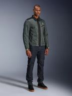 Giacca Alpinestars Ignite Air, Urban Gray Black Blue, giacca da moto urban, indossata da un modello con jeans in denim scuro e sneakers nere, caratterizzata da un corpo in rete, colletto a camicia tradizionale, silhouette d’ispirazione Harrington e logo Alpinestars dorato.