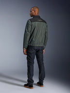 Giacca Alpinestars Ignite Air in Urban Gray Black Blue, vista posteriore su modello, con corpo in mesh, sprone nero sulle spalle e scritte bianche, polsini a righe, abbinata a jeans in denim scuro e sneakers nere, abbigliamento moto urban lifestyle