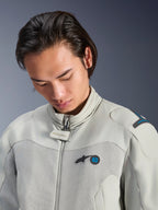 Modello che indossa la giacca Alpinestars Circal-1 Air in Metal Gray con accenti Methyl Blue, vista ravvicinata che mette in risalto il colletto, i pannelli in rete sul petto e il logo minimalista, abbigliamento da moto urbano sostenibile.