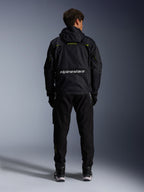 Alpinestars Mogress Air Jacket, giacca da moto urbana, vista posteriore in nero con accenti lime punch e bianchi, con marchio Alpinestars sulla parte bassa della schiena, indossata con pantaloni e stivali neri