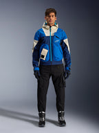 Giacca Alpinestars Mogress Air, giacca da moto urbana Blue Almond, indossata con pantaloni e stivali neri, caratterizzata da un design tecnico color-block blu e crema con tasche utility e cappuccio, abbigliamento da moto contemporaneo ispirato allo streetwear