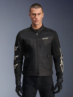 Alpinestars T-Dyno Air Jacket, giacca da moto in tessuto nera, con grafiche a stella bianche sulle maniche e logo sul petto, pannelli in mesh per la ventilazione, vestibilità biker d'ispirazione vintage, indossata con guanti e pantaloni neri