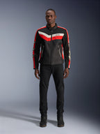 Alpinestars T-Dyno Air Jacket, giacca da moto in tessuto, nero, rosso brillante ed ecrù, indossata da un modello con pantaloni e stivali neri, caratterizzata da un design d'ispirazione vintage con vivaci strisce colorate sul petto, loghi a stella sulle maniche e struttura in mesh traspirante per la guida urbana.