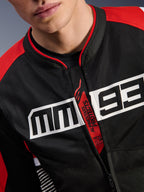 Alpinestars MM93 T-SPS Air V2 Jacket, giacca da moto, nero, rosso brillante e bianco, primo piano del petto con grande logo MM93 bianco, tiretto della cerniera rosso 'Alpinestars Protects' e 'Tech-Air Ready', trama in tessuto mesh tecnico